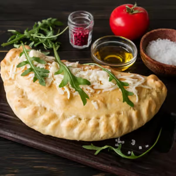 Angelo's Pizza House calzone, topped with melted cheese and fresh arugula, on a wooden board.